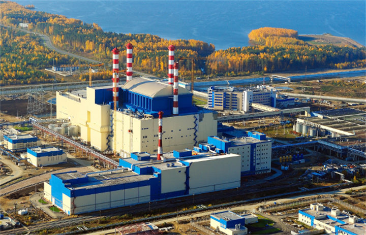  Aerial shot of large advanced nuclear power station beside forested lakeshore