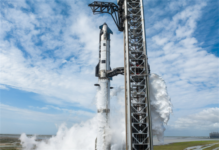 Starship prototype at launch tower venting cryogenic white vapor ahead of test launch