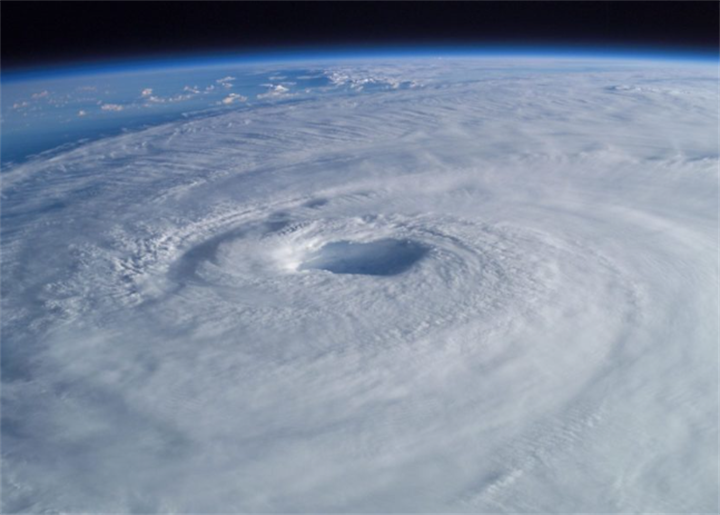 Space overhead satellite photo of massive hurricane eye within spiral cloud formation